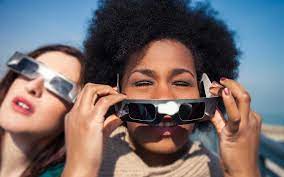 image of two women wearing solar eclipse glasses