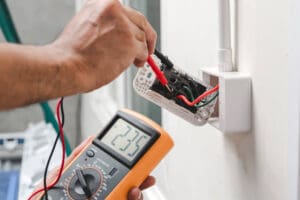 electrician conducting an inspection on an electrical outlet 